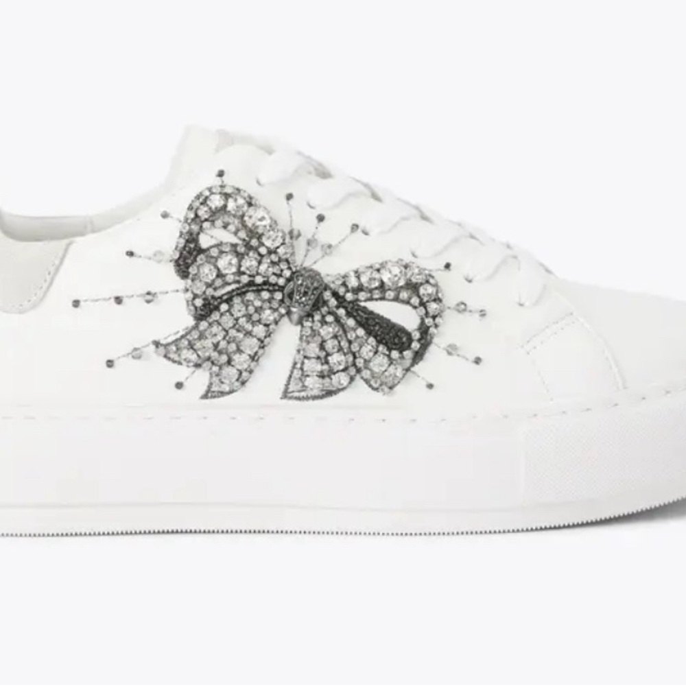 The Laney Bow Embellished features a white leather upper.